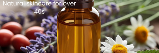 amber glass bottle of liquid surrounded by rosehips, chamomile flowers and lavender