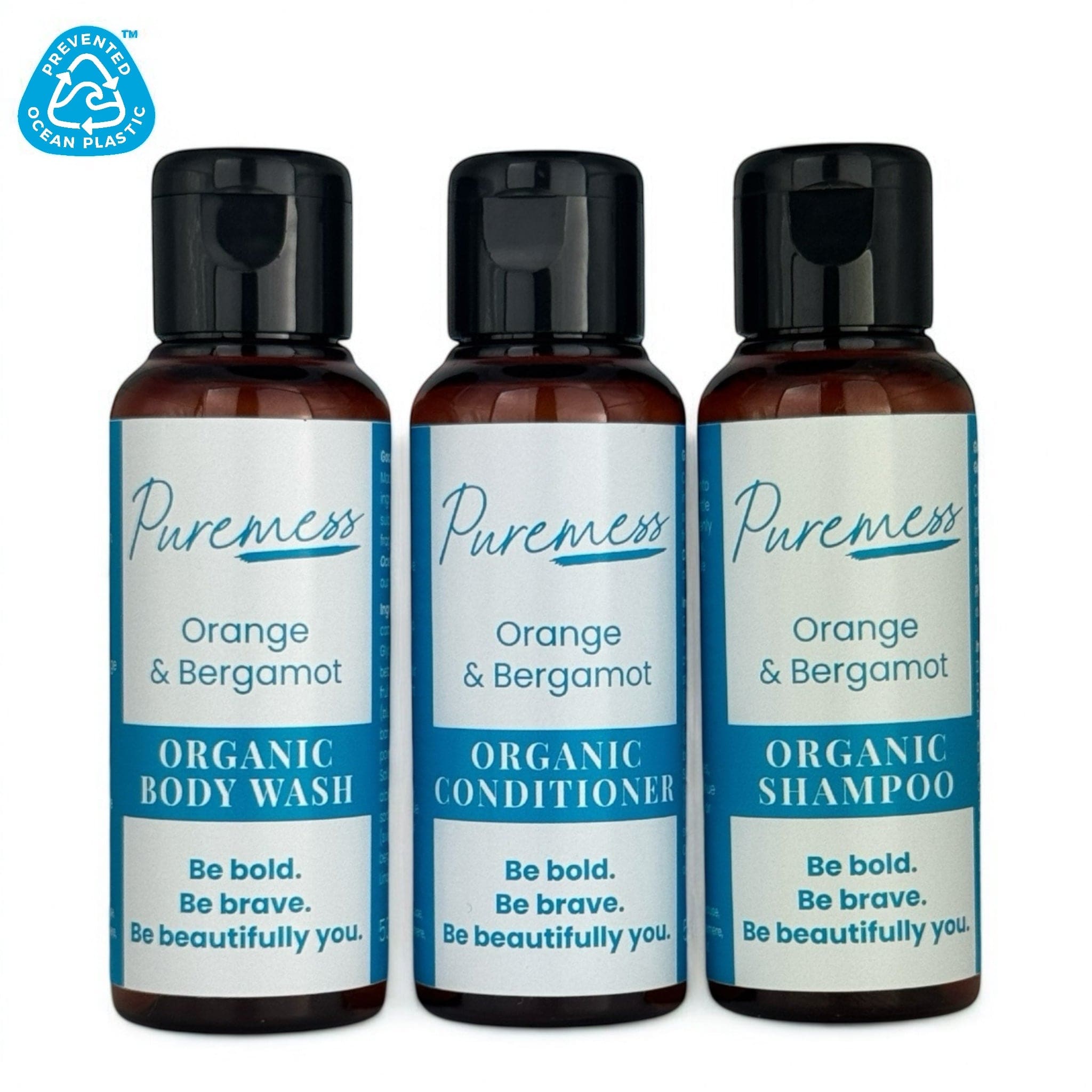 Set of three 50ml amber bottles with black caps labeled Puremess Orange & Bergamot organic body wash, conditioner, and. - PUREMESS SKINCARE - Orange & Bergamot Travel Set | Shampoo, Conditioner & Wash 50ml